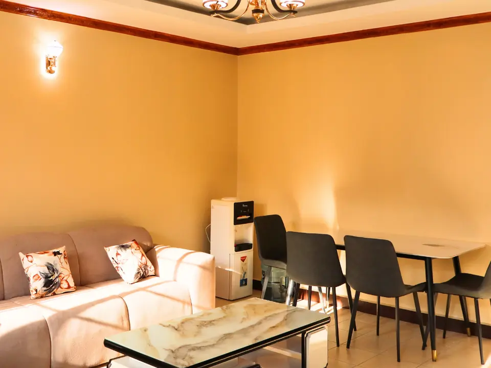 Sitting room with a sofa, marble-top coffee table and a four-seat dining table