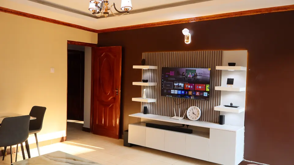 Sitting room TV wall with a smart TV and lit shelving
